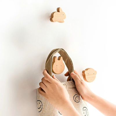 main qui suspend sac sur patere bois forme tete lapin