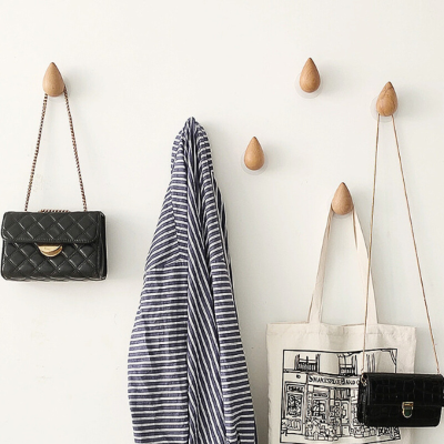 veste sacs accrochés sur patère en bois forme goutte