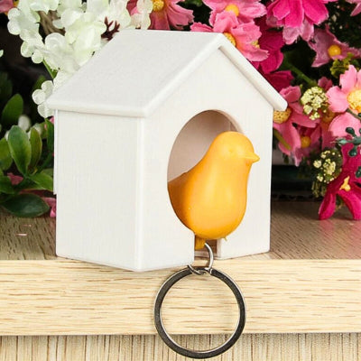 porte clé oiseau jaune dans maison blanche