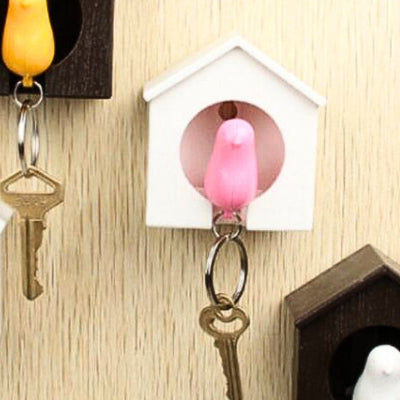 porte clé oiseau rose dans maison blanche
