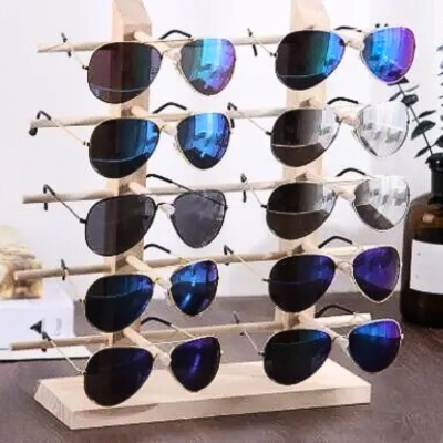 dix paires de lunettes rangées sur portant en bois