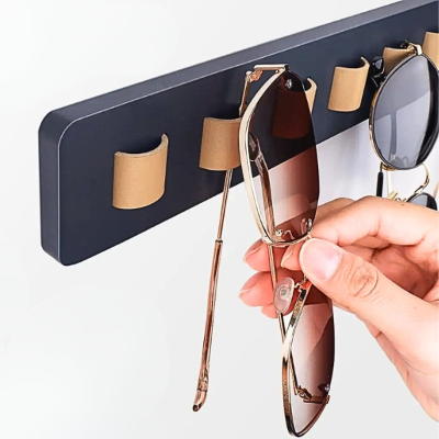 main qui range paire lunette dans porte lunettes mural