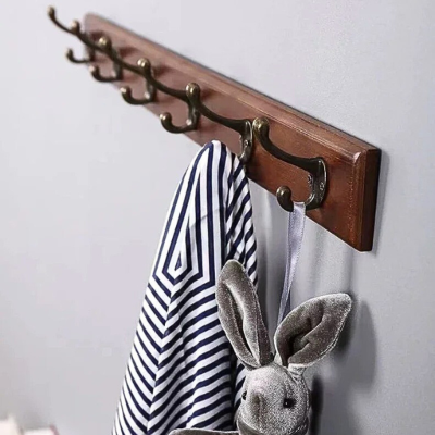 peluche lapin et veste accrochés sur porte manteau en bois