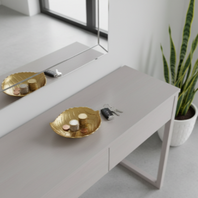 vide poche doré forme feuille sur commode grise entrée
