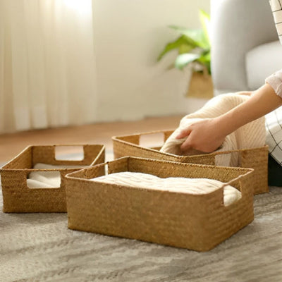 mains rangent vêtements dans panier rangement rotin naturel