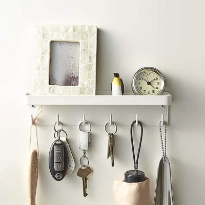 cadre blanc posé sur porte clés mural blanc avec horloge