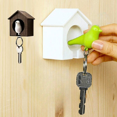 porte clé oiseau vert dans maison blanche