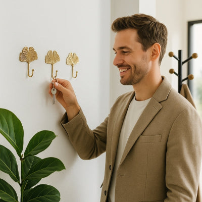 homme accroche trousseau clés porte clef mural feuille dorée