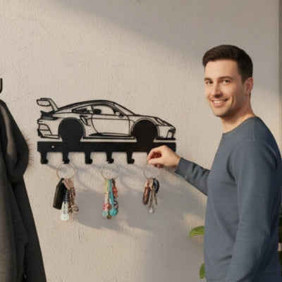homme souriant accroche clé sur porte clés mural voiture course