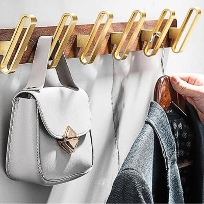 main accroche veste sur porte manteau doré bois aluminium