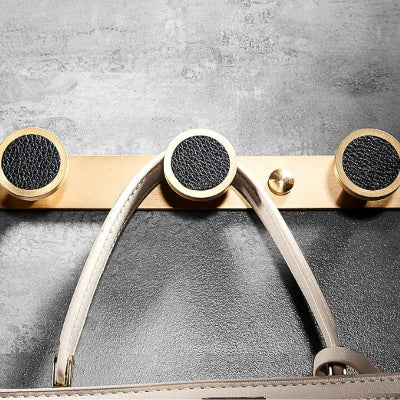 anse sac sur porte manteau mural doré boutons noir cuir
