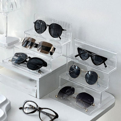 collection lunettes soleil rangées sur présentoir à lunettes transparent